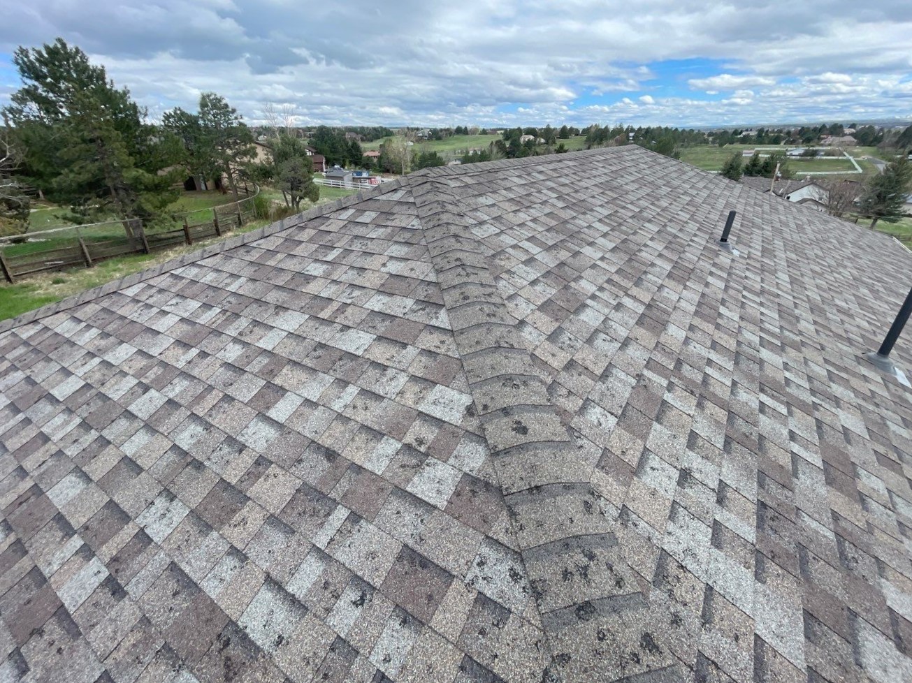 Hail-damaged asphalt shingles showing circular bruising and granule loss on a Maryland home, documented for insurance claim before roof replacement