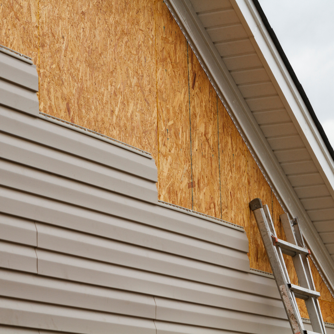 Storm-damaged vinyl siding being replaced in Middle River, Maryland with exposed OSB sheathing visible